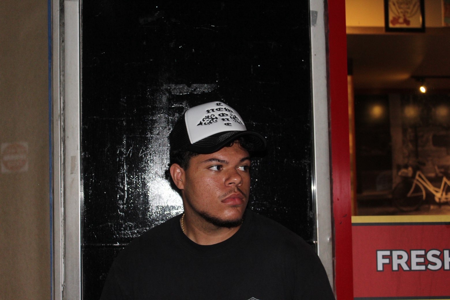 Trucker hat after dark, black doorway